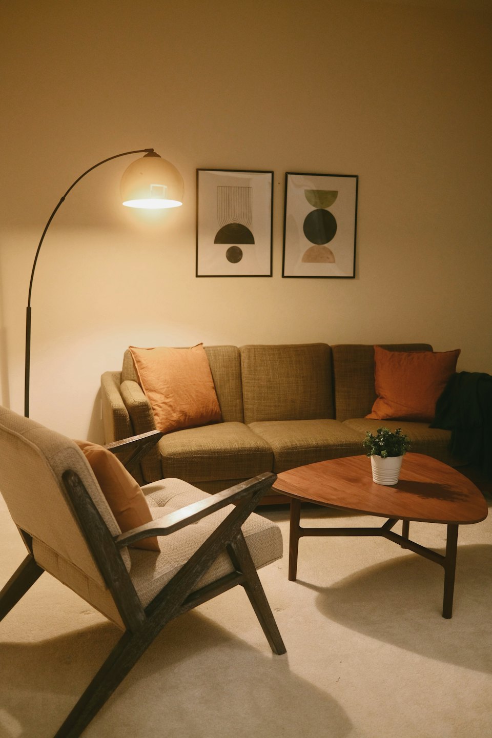 Vardagsrum i mellankrigstidens modernism med grå fåtölj och soffa.